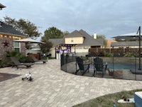 a backyard with a pool and patio furniture